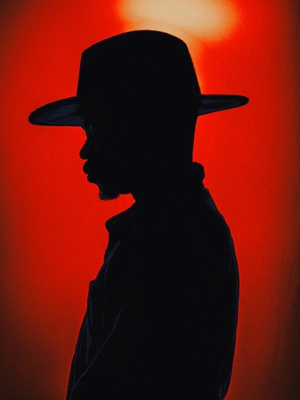 Red-lit creative portrait with a hat