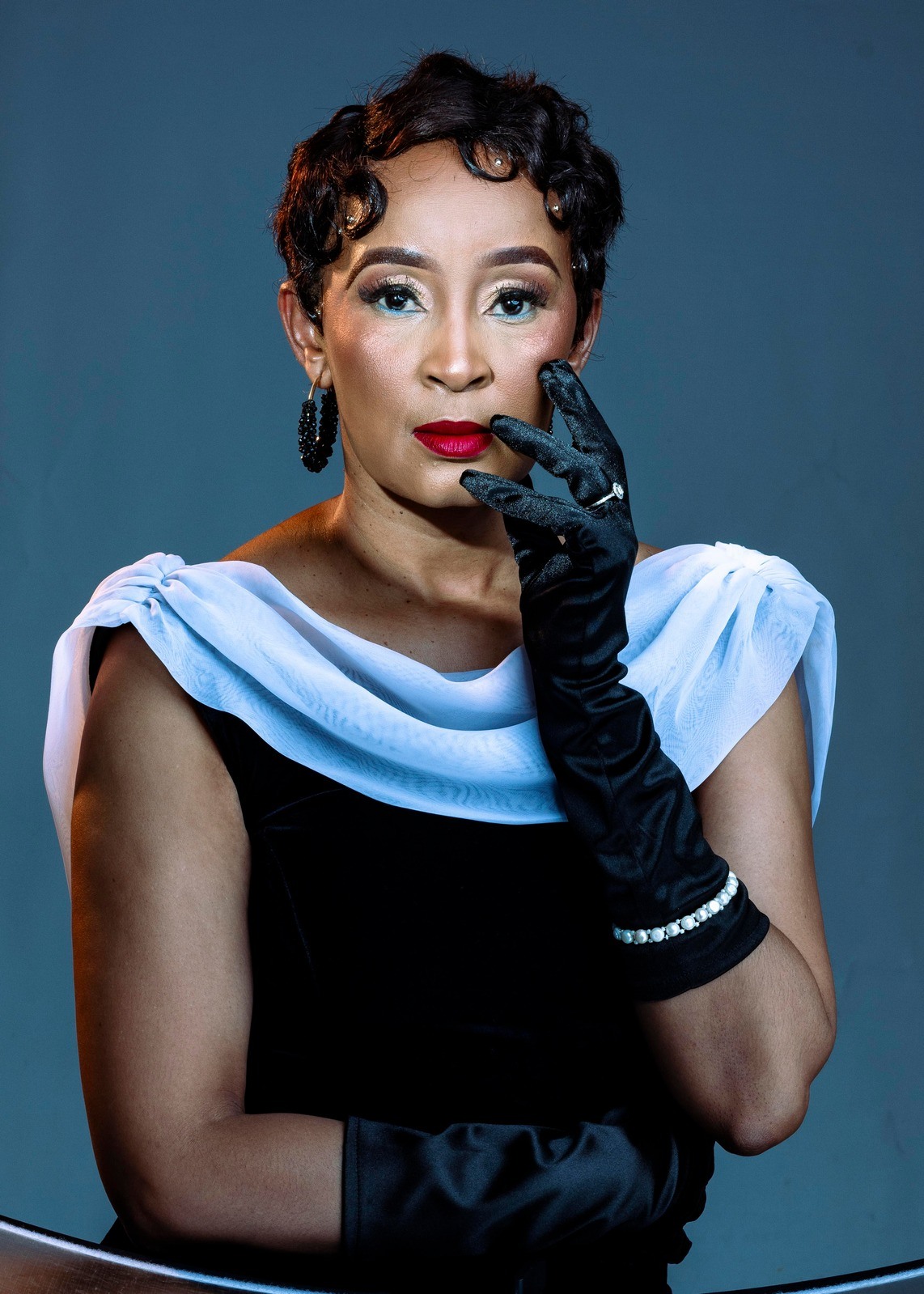Editorial portrait in blue, with a black glove