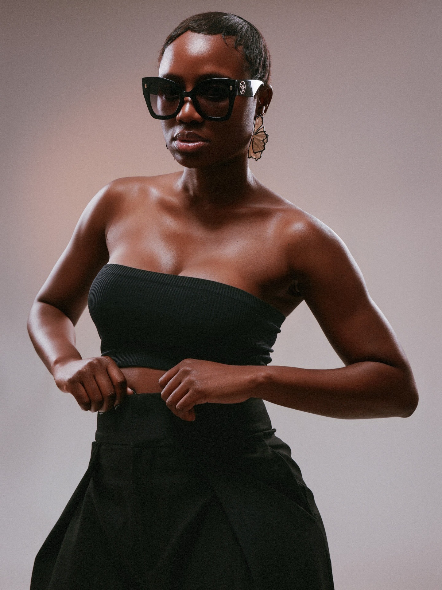 Fashion portrait with sunglasses against a neutral backdrop