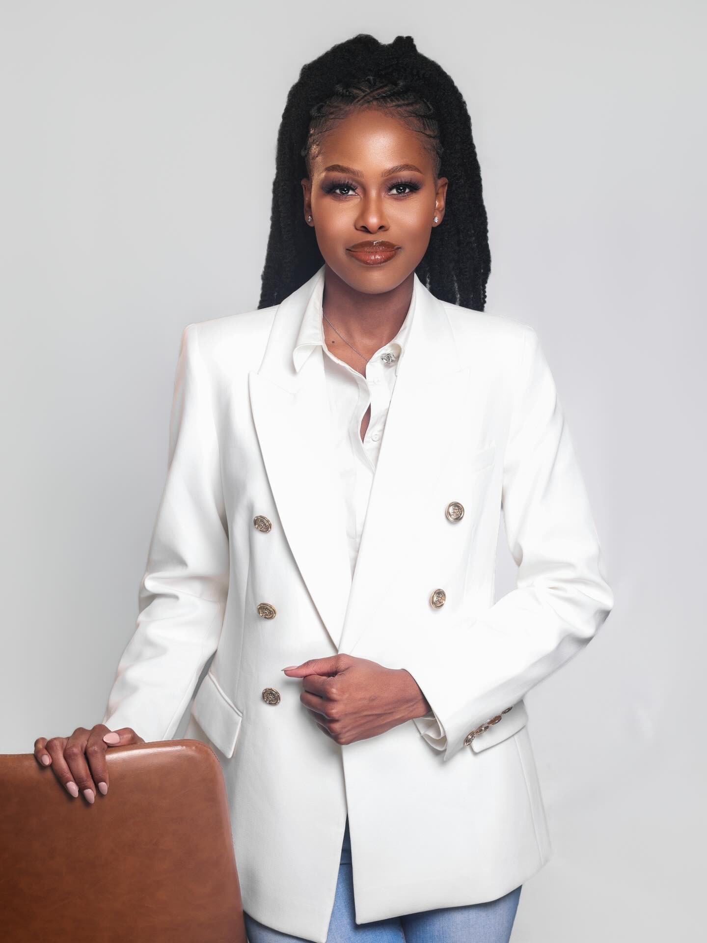 Portrait in a white blazer against a light grey backdrop